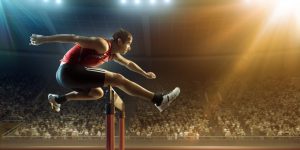 Male athlete hurdling on sports race